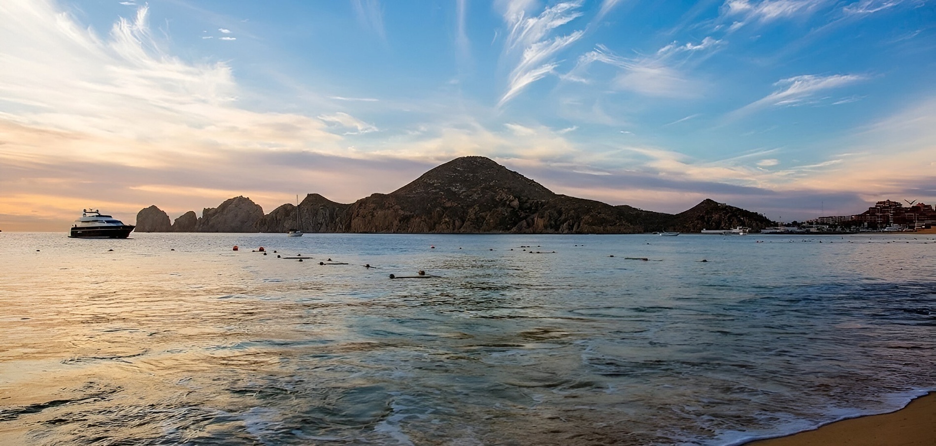 un barco en el océano con una montaña en el fondo