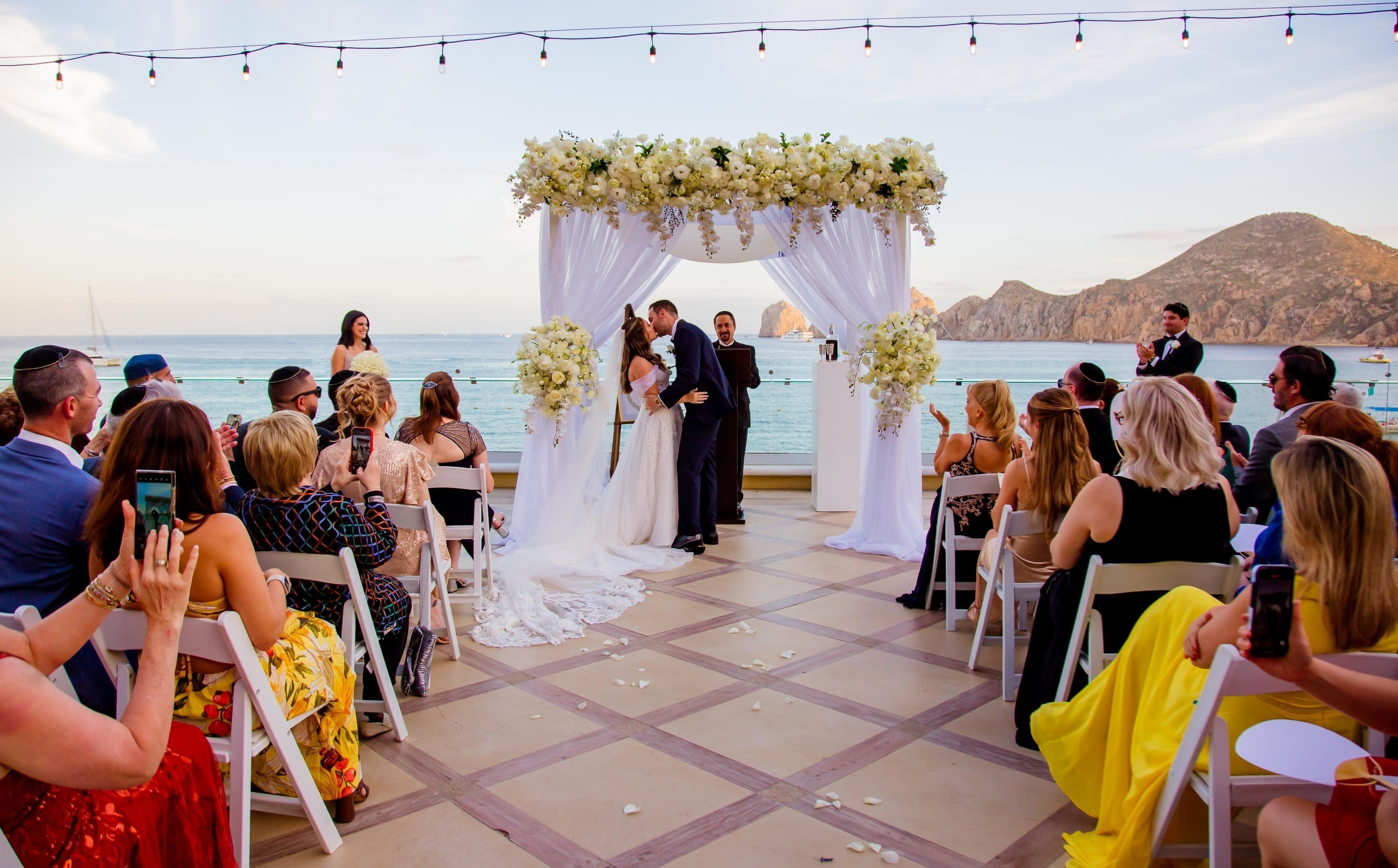 ein weißer bogen mit blumen darauf und einem meer im hintergrund .