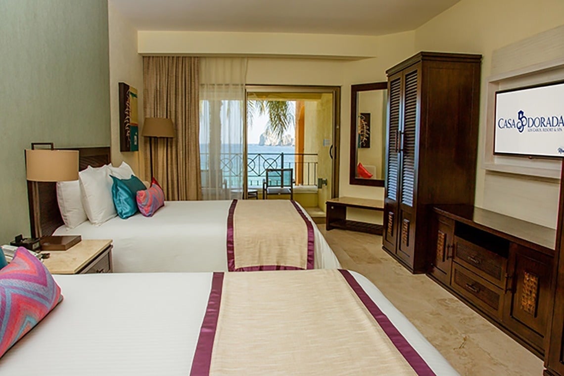 ein Hotelzimmer mit zwei Betten und einem Fernseher mit der Aufschrift casa dorada