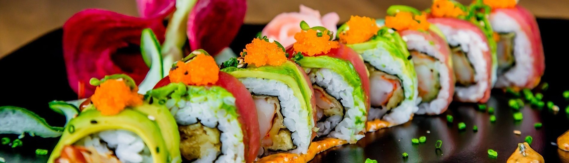 un primer plano de un plato de sushi con aguacate y camarones