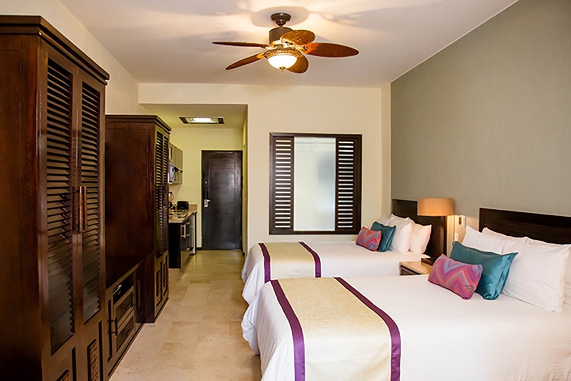 a hotel room with two beds and a ceiling fan