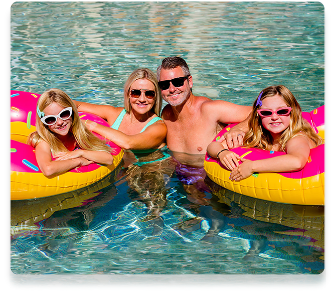 a family in a swimming pool with floats that look like donuts