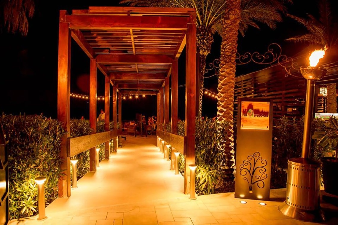 une longue allée en bois éclairée la nuit