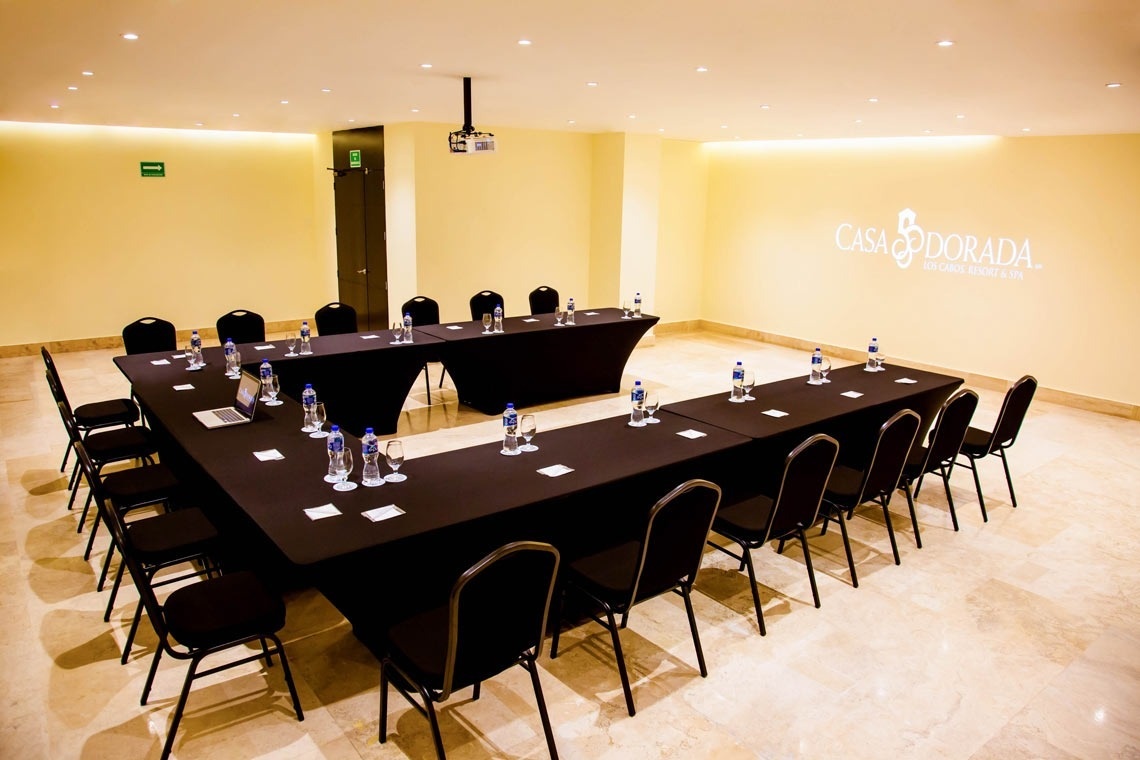 ein Konferenzraum mit einem Tisch und Stühlen und einem Gemälde an der Wand