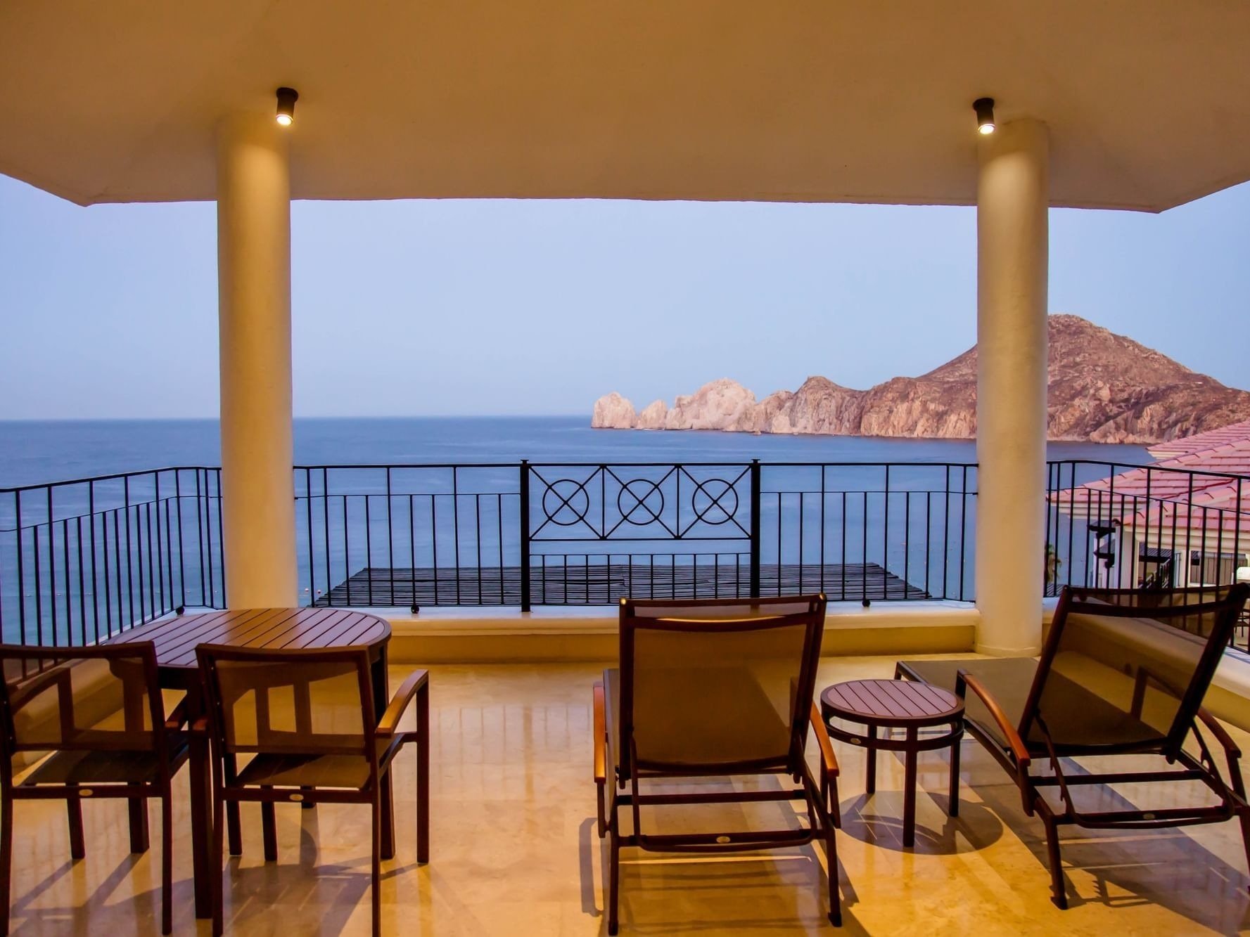 ein Balkon mit einem Tisch und Stühlen mit Blick auf das Meer