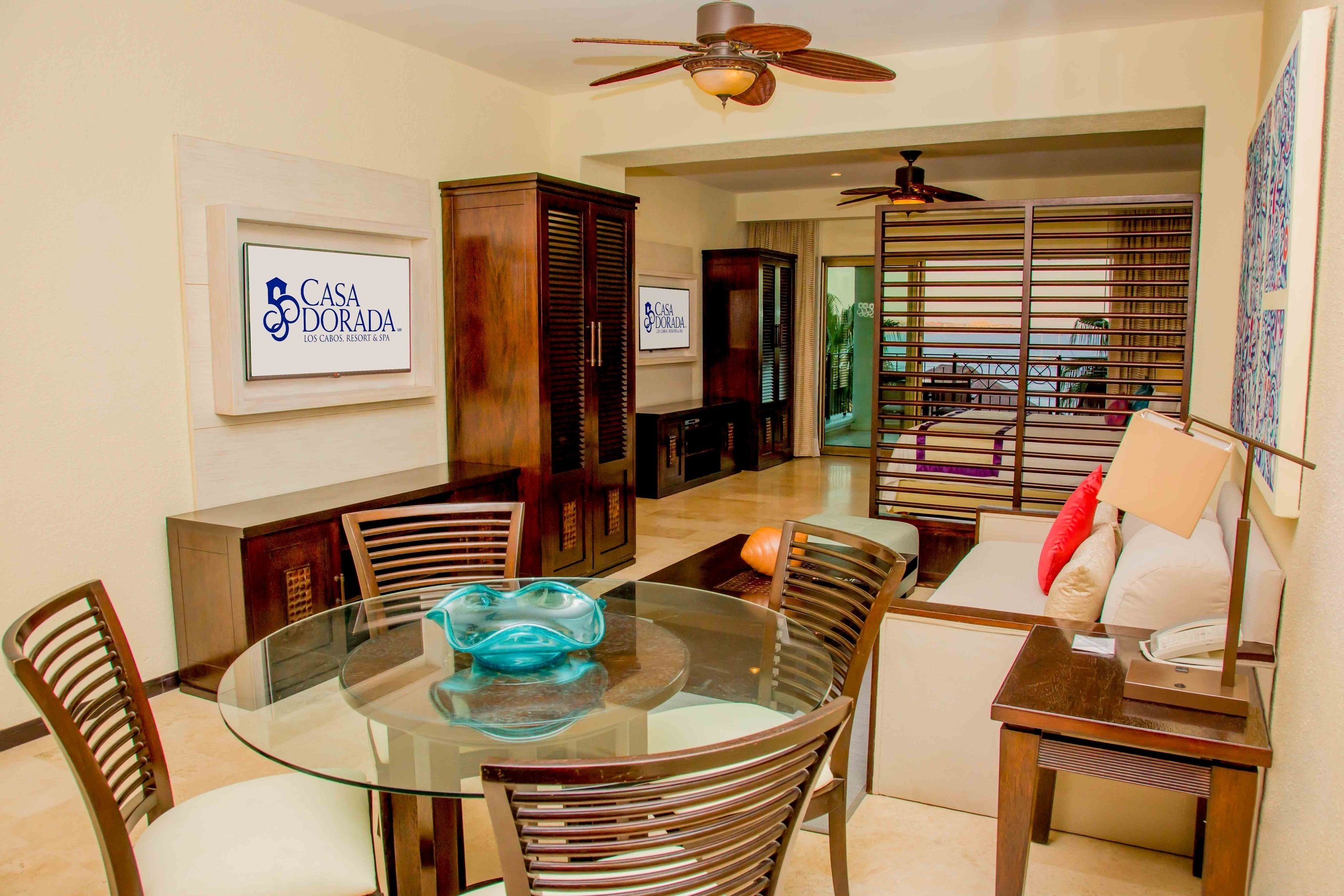 ein Wohnzimmer mit einem Tisch und Stühlen und einem Fernseher mit der Aufschrift casa dorada