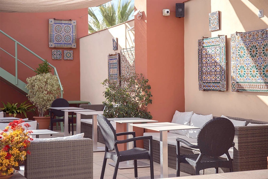 un patio con mesas y sillas y azulejos en las paredes