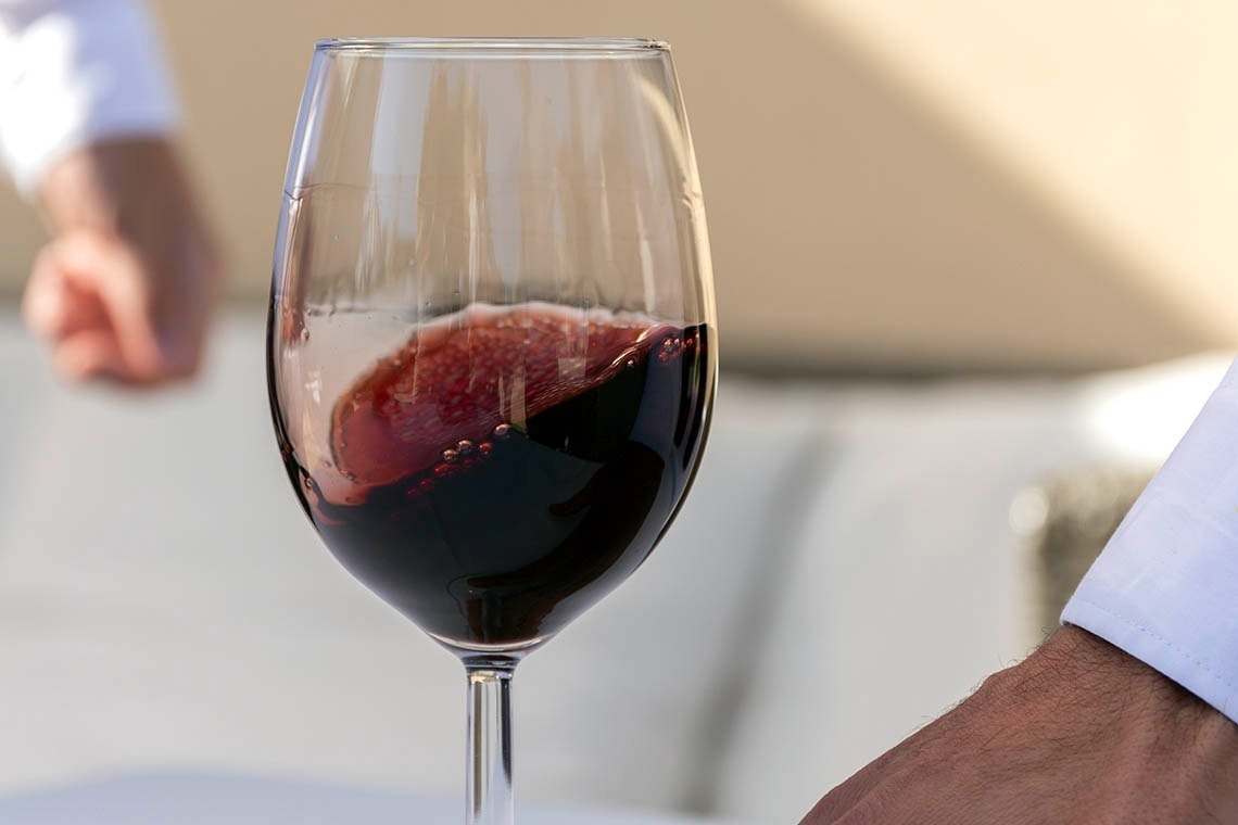 a close up of a glass of red wine on a table