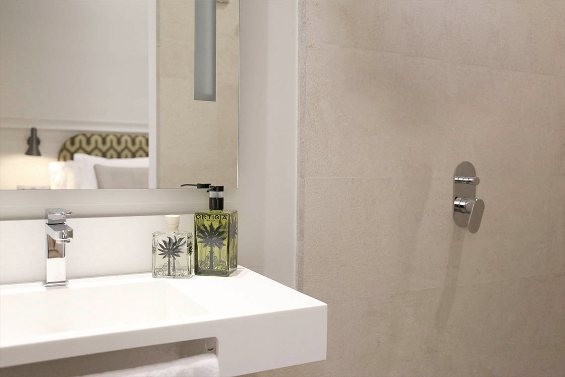 un baño con un lavabo y dos botellas de perfume