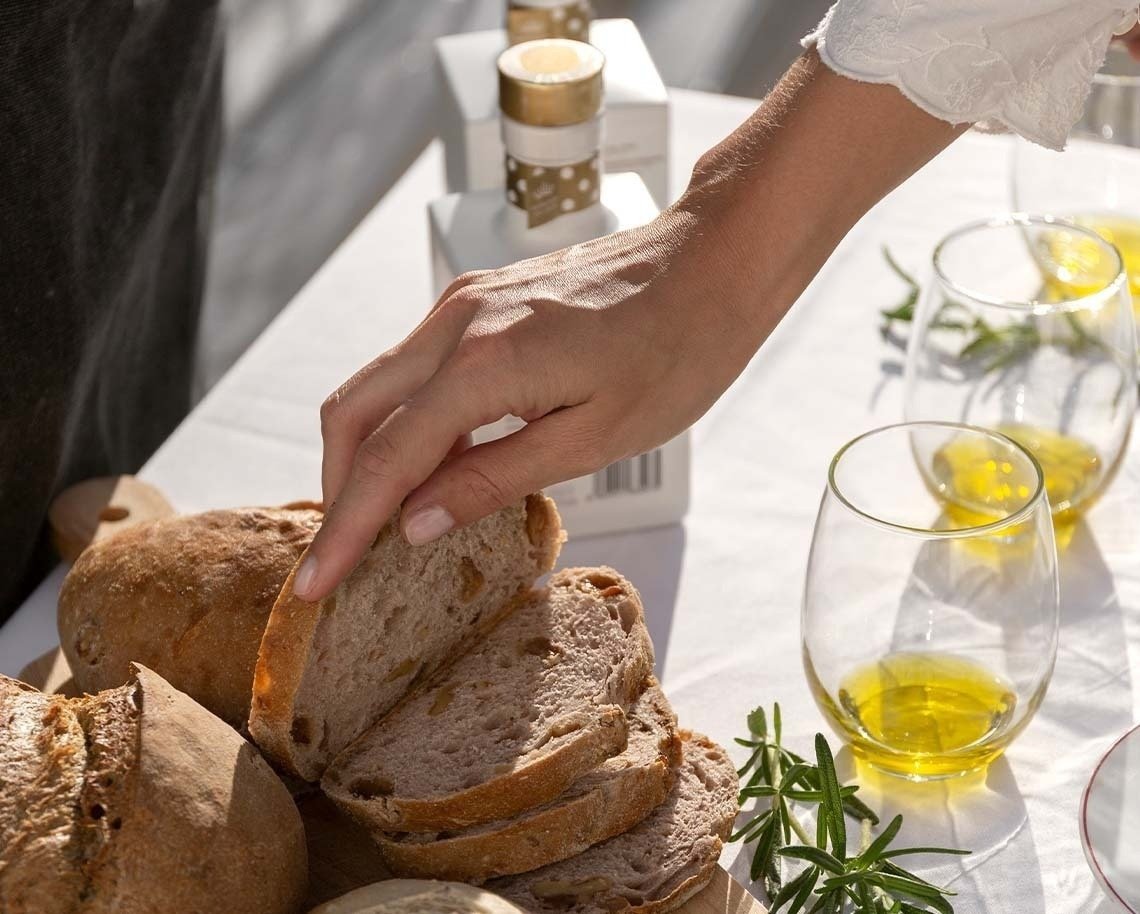 a woman reaches for a slice of bread on a table