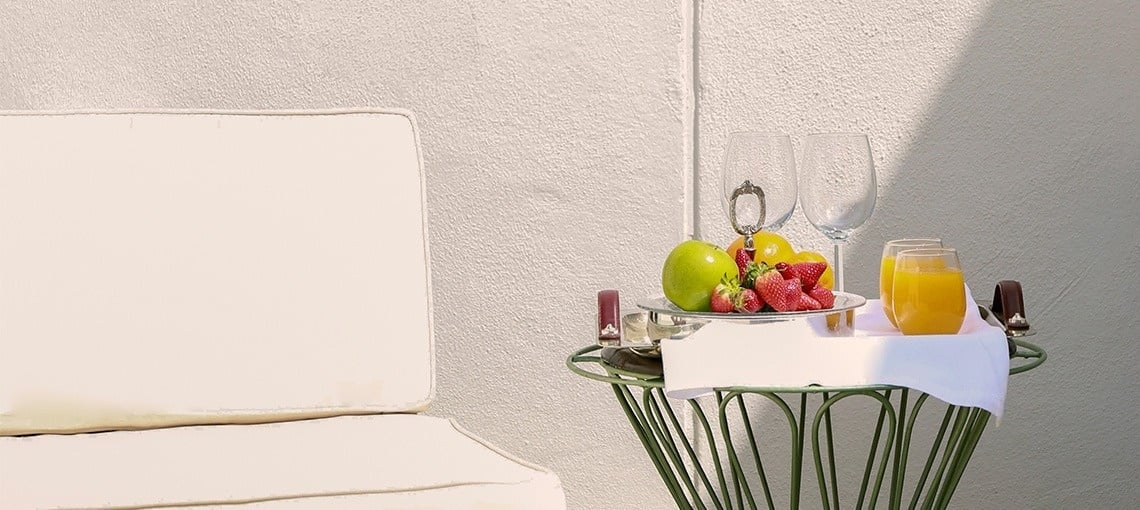 una mesa con un plato de frutas y dos copas de vino