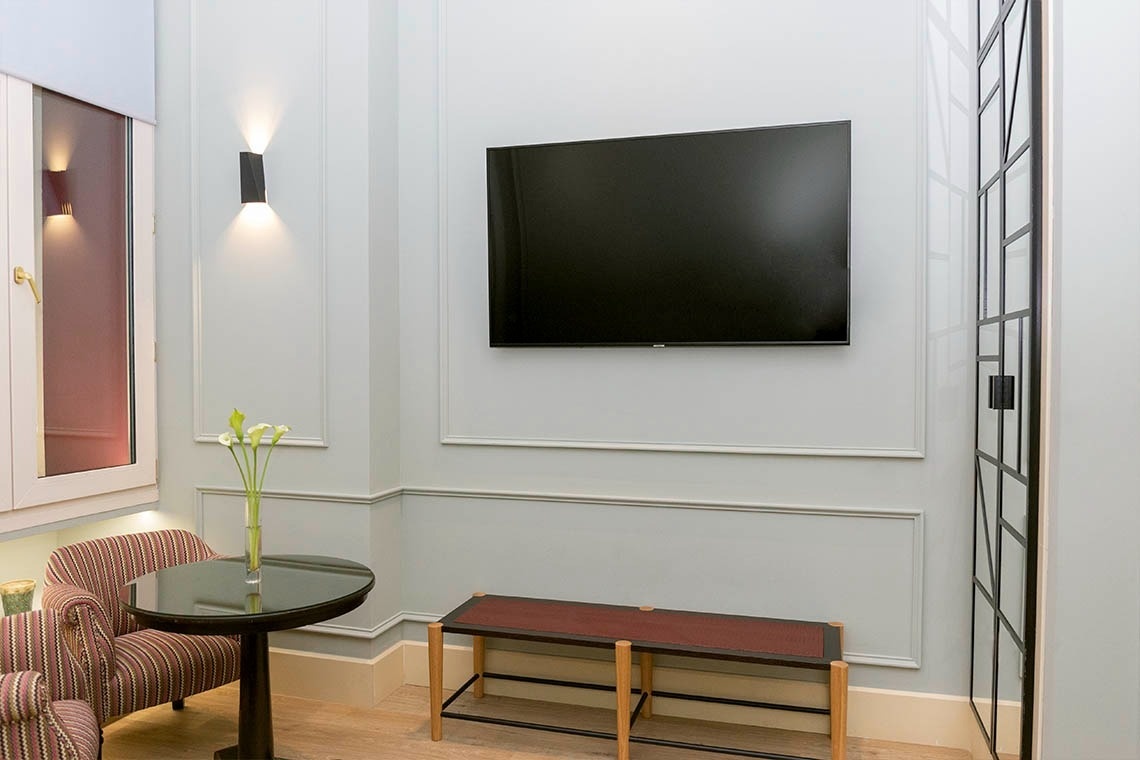 una habitación con una mesa y una televisión en la pared