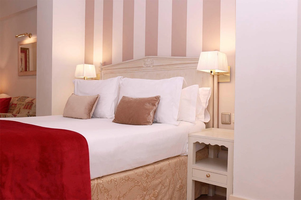 una habitación de hotel con una cama y una mesita de noche