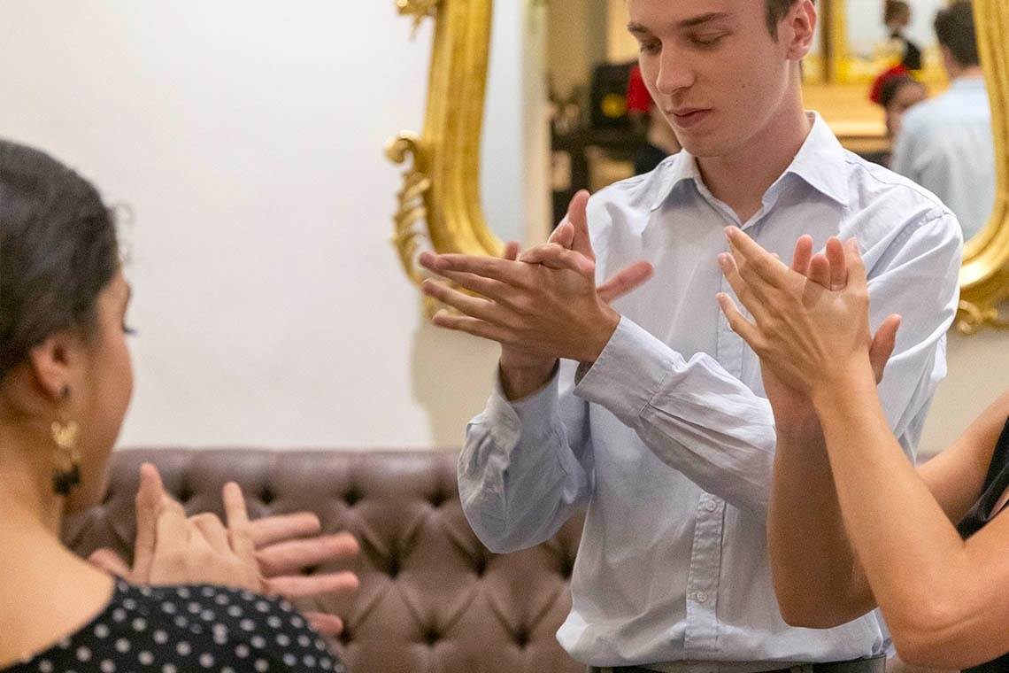 a man and woman are clapping their hands in front of a mirror