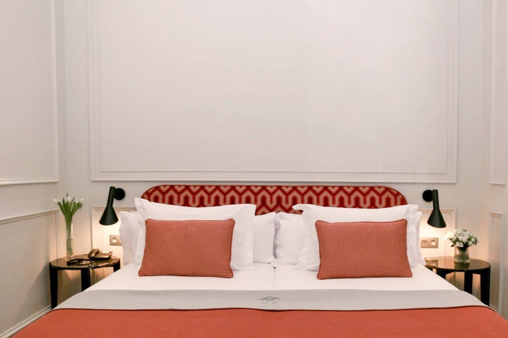 una cama con almohadas rojas y blancas en una habitación