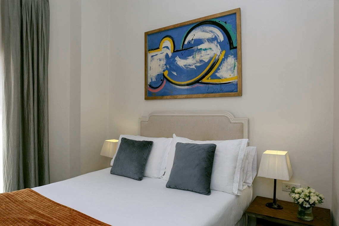 un dormitorio con una cama y una pintura en la pared