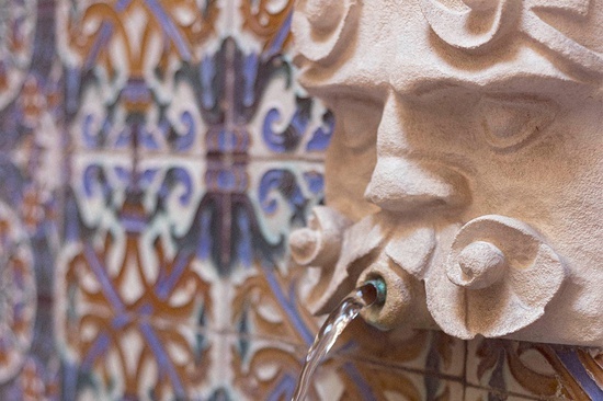 un primer plano de una estatua de una cara con agua que sale de la boca