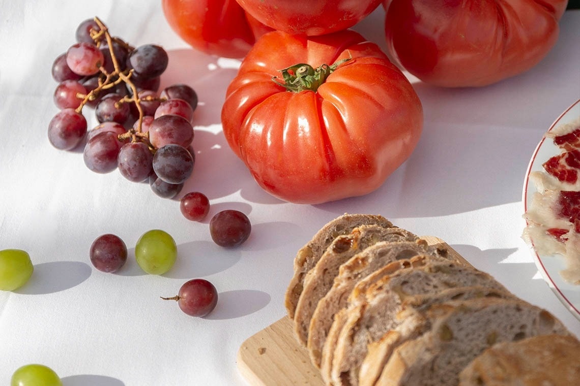 slices of bread grapes and tomatoes on a table