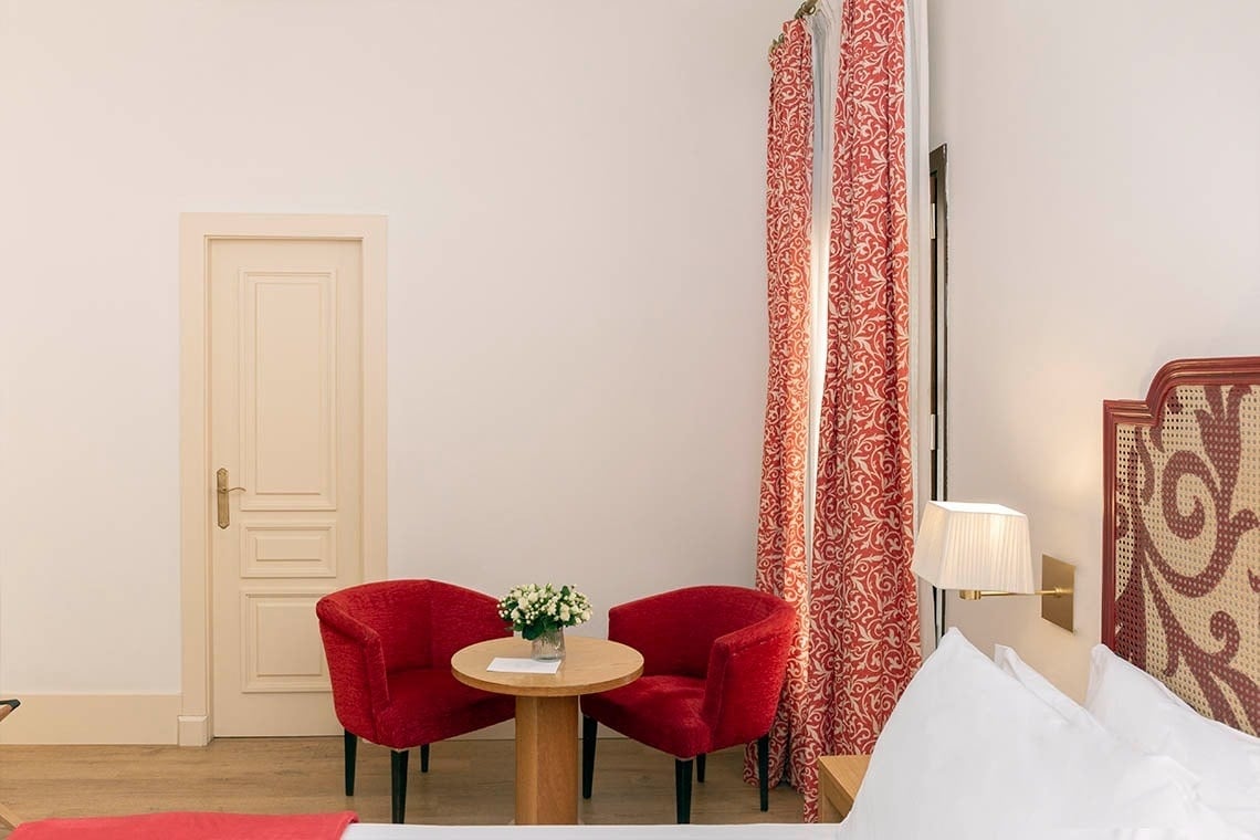 una habitación con dos sillas rojas y una mesa de madera