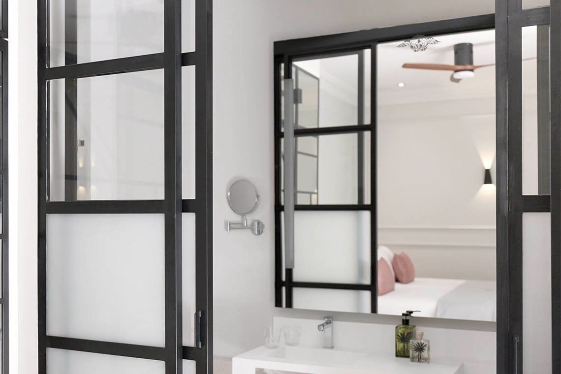 un baño con una puerta corrediza de vidrio y un espejo