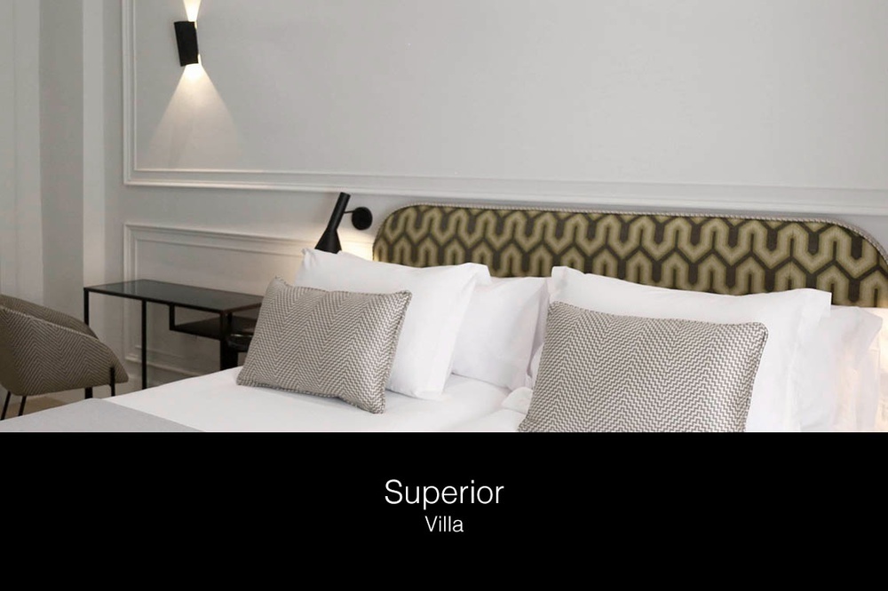 a bed with white sheets and pillows in a superior villa