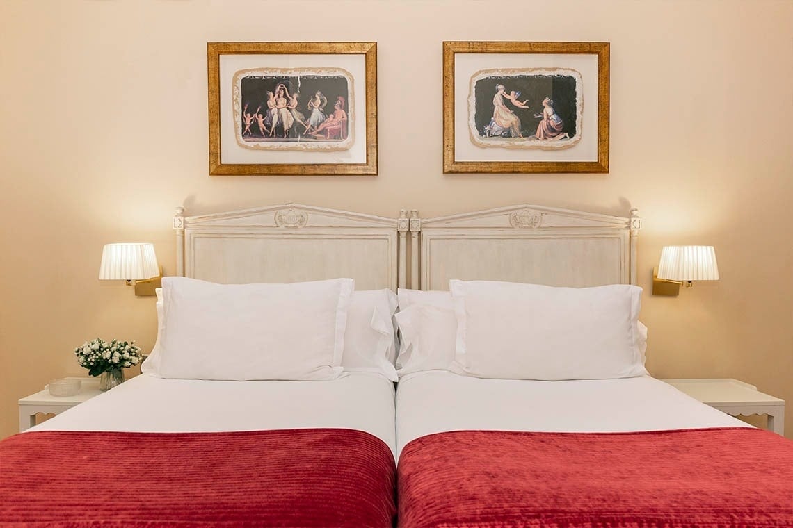 una habitación con dos camas y dos cuadros en la pared