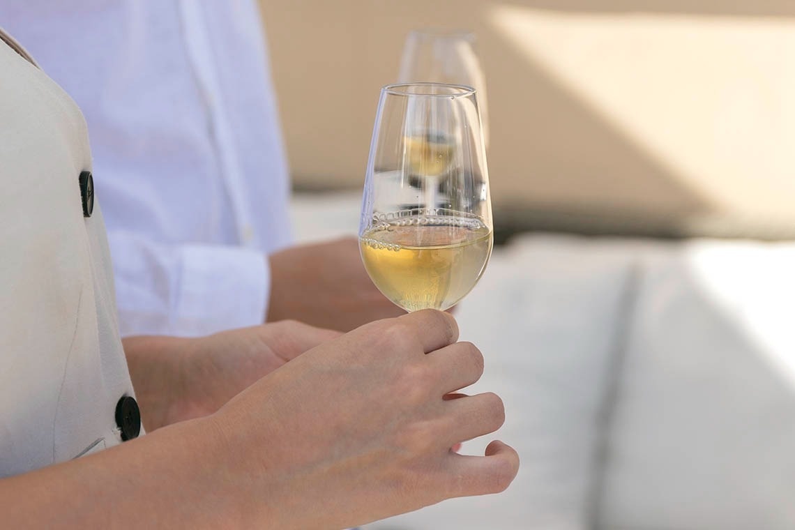 a person is holding a glass of champagne in their hand