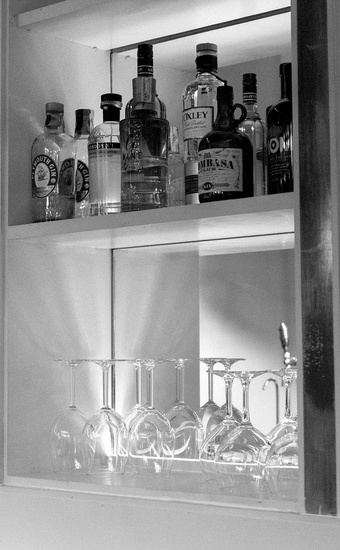 un estante lleno de botellas de alcohol y copas de vino