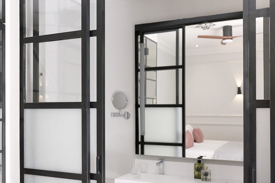 un baño con una puerta corrediza de vidrio y un espejo
