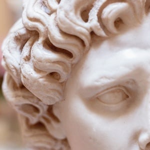 un primer plano de una estatua de un niño con cabello rizado