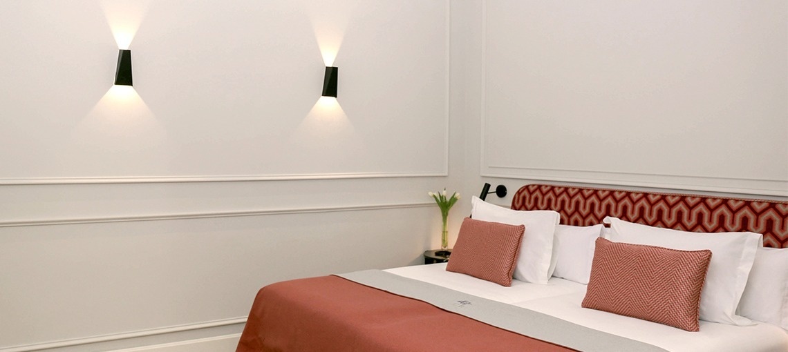 una habitación de hotel con una cama y dos lámparas