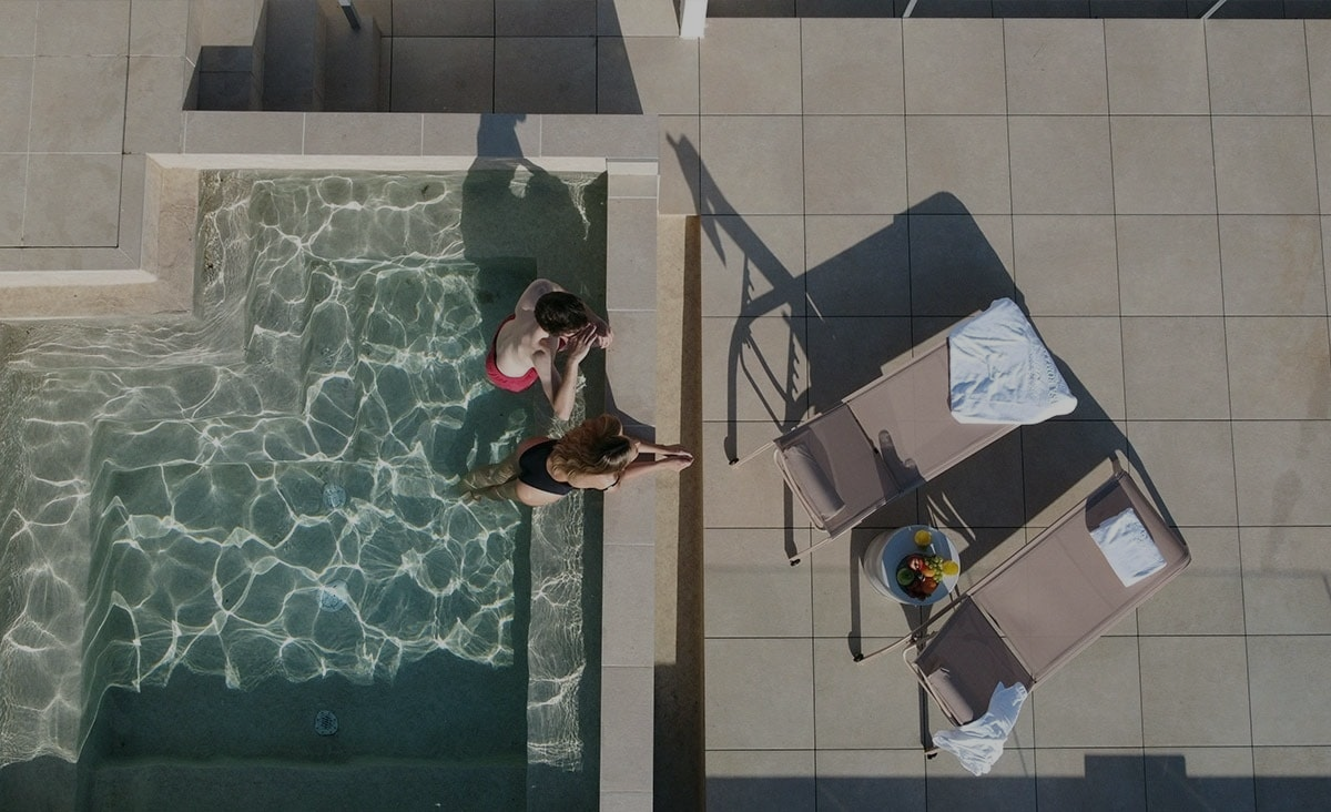 Pareja relajándose en la piscina de Casa Romana Boutique, estilo italiano.