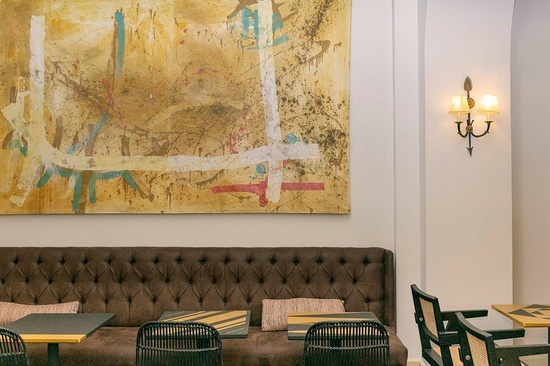 una habitación con mesas y sillas y una pintura en la pared