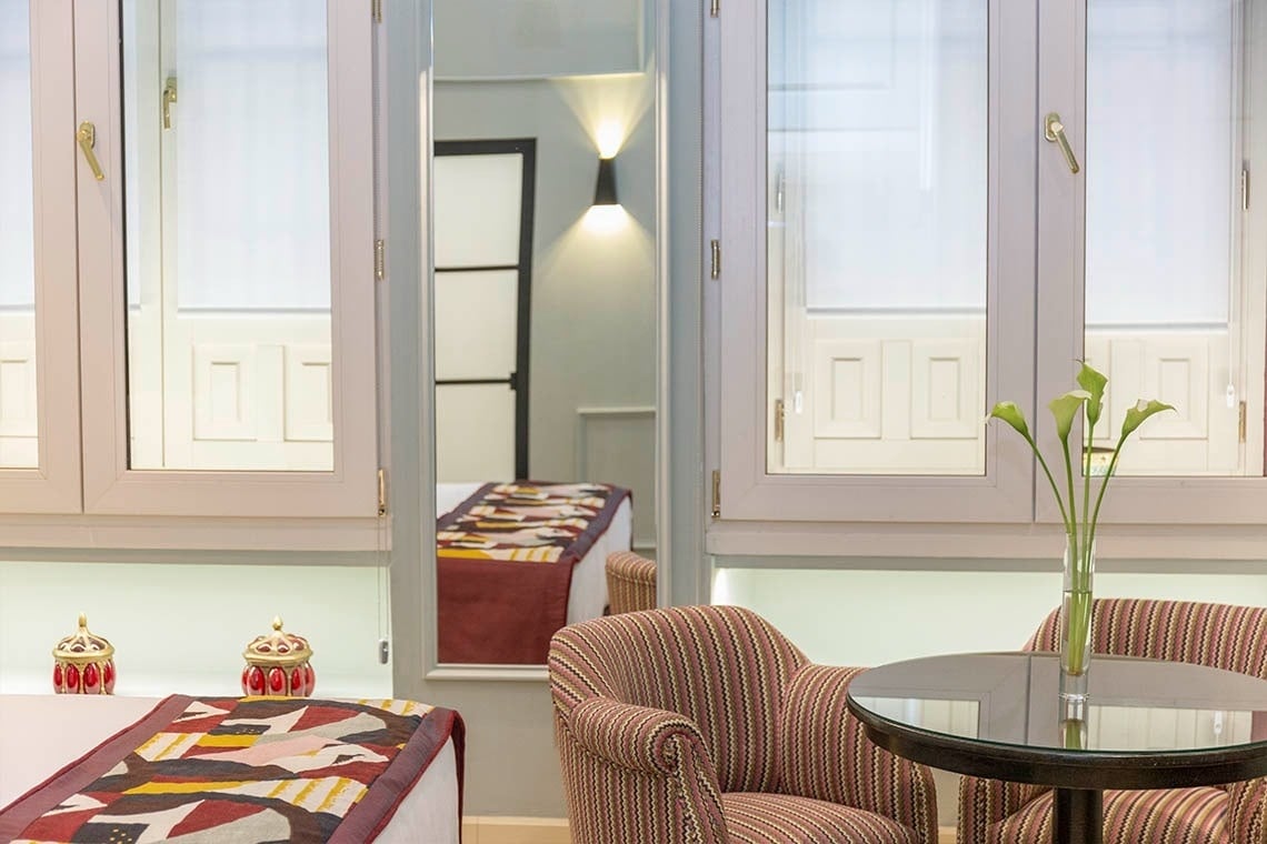 una habitación con dos sillas y una mesa con un jarrón de flores