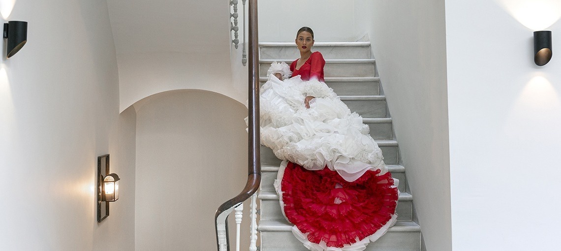 a woman in a red and white dress is walking down a set of stairs