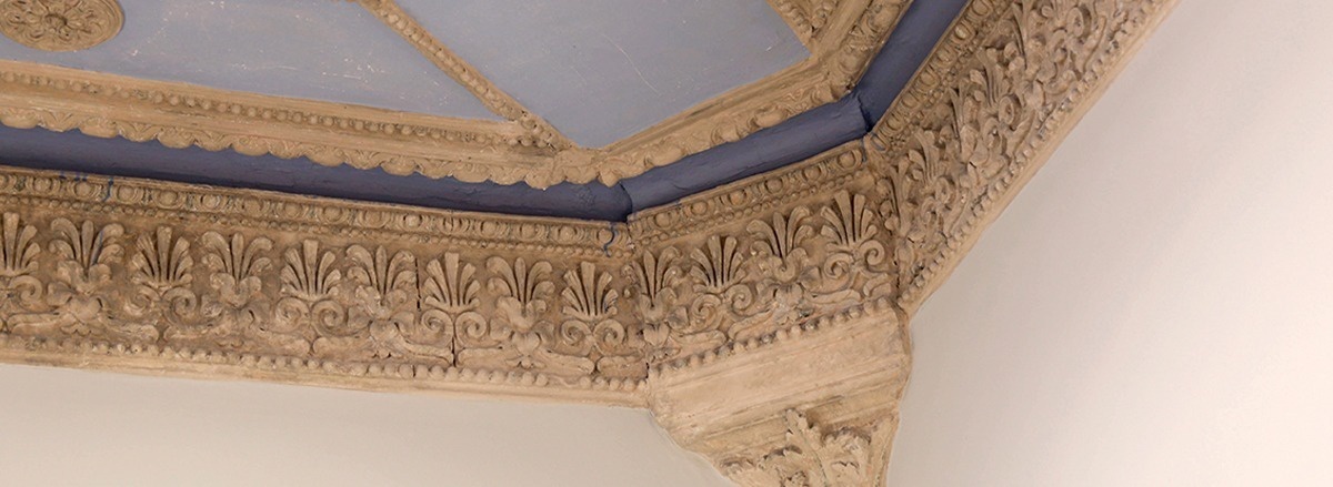 a corner of a building with a blue ceiling