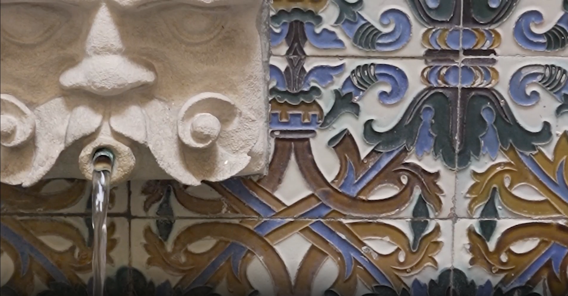 una fuente de agua con una cara tallada en la pared
