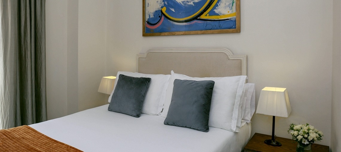 un dormitorio con una cama y una pintura en la pared