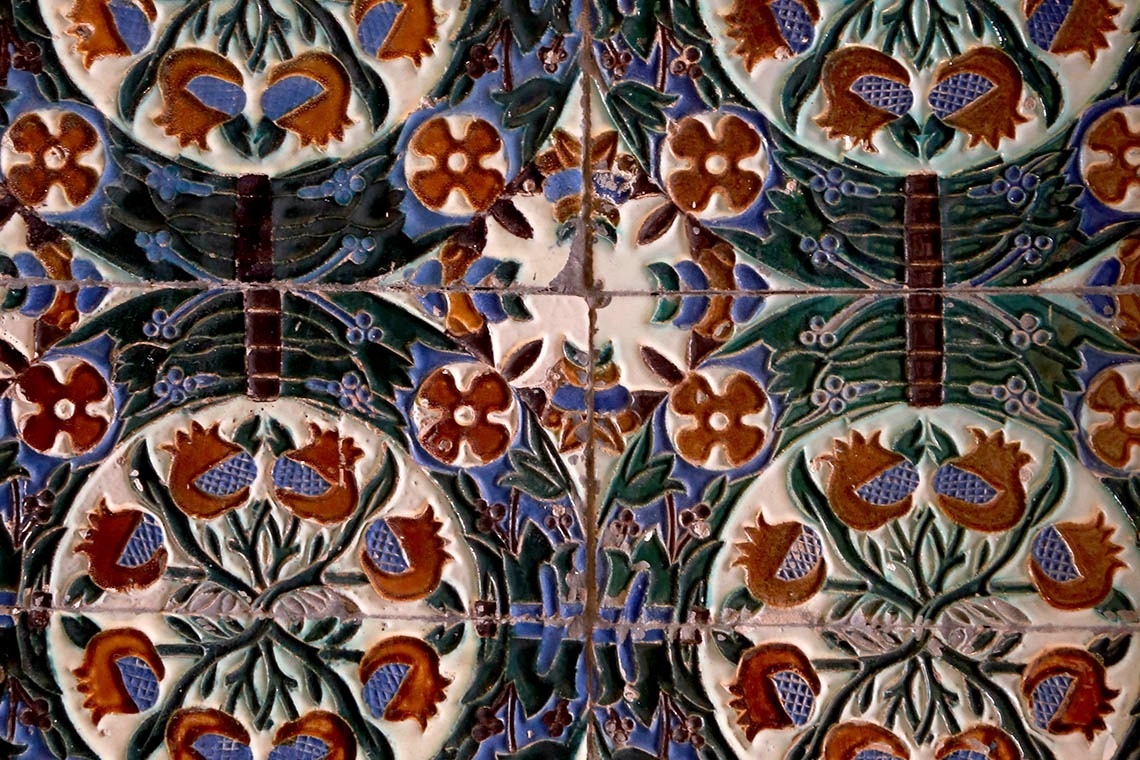 a colorful tile with flowers and butterflies on it