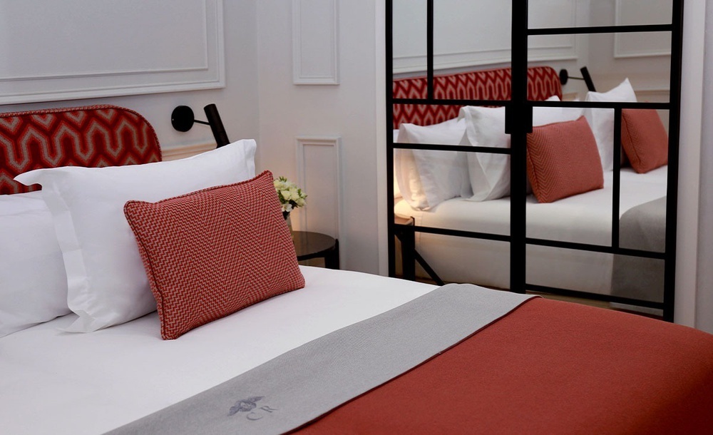 una cama con almohadas rojas y blancas en una habitación