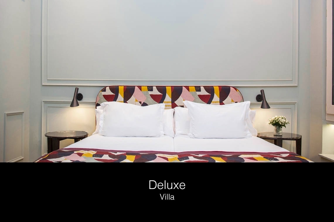una cama de lujo con una cabecera colorida y almohadas blancas