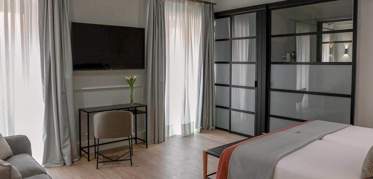 una habitación con una cama y una televisión en la pared