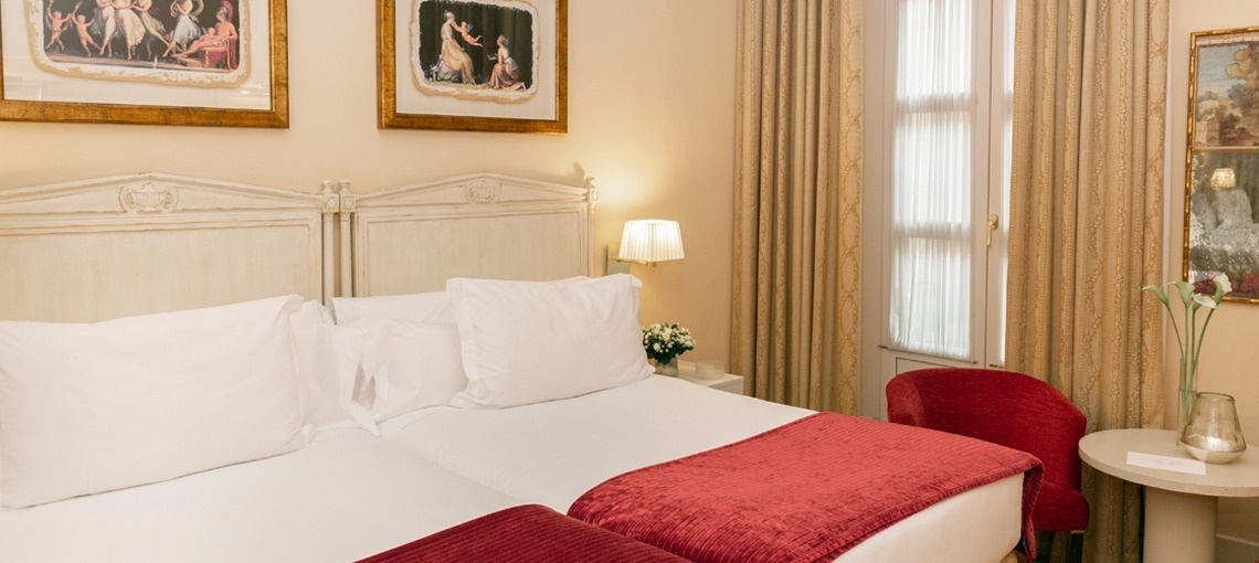 una habitación con dos camas y dos cuadros en las paredes