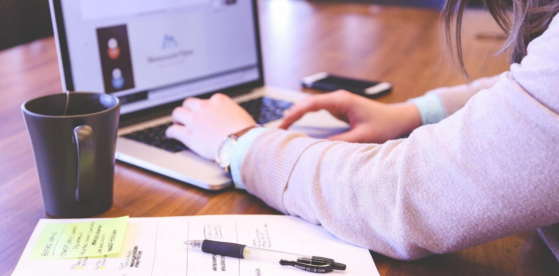 una mujer está usando una computadora portátil en una mesa
