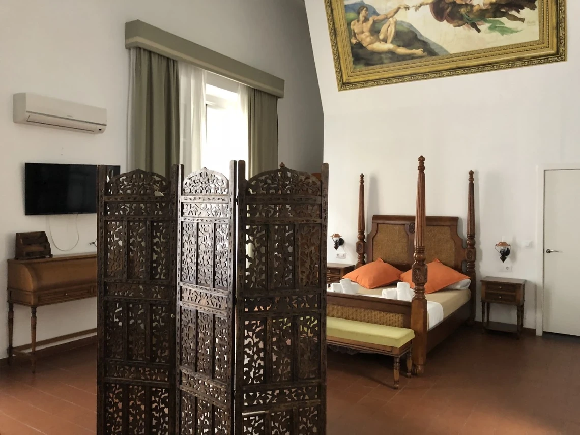 Dormitorio con cama de dosel,Casual Alquimia Cádiz y arte clásico.
