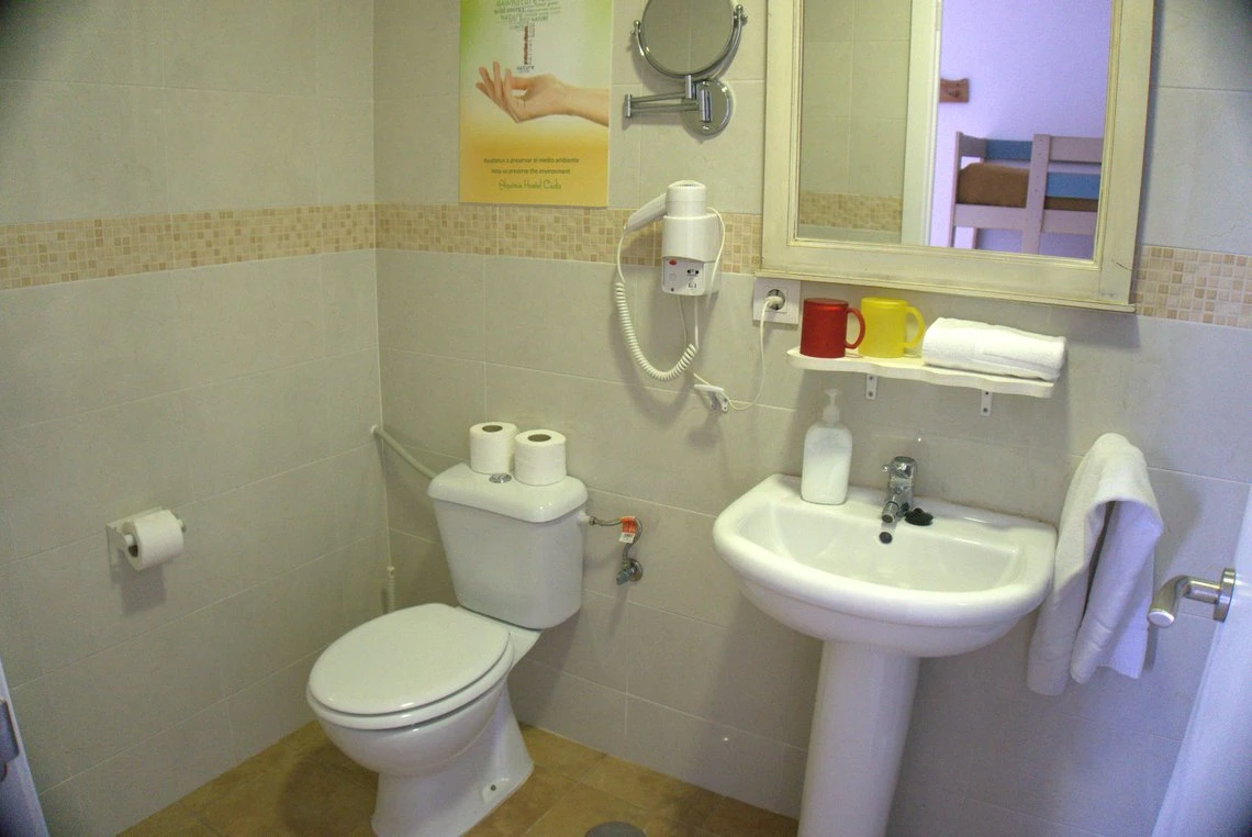 Baño con inodoro, lavabo y secador de pelo. Ideal para tu Casual Alquimia Cádiz.