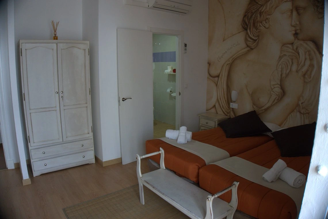 Habitación doble con mural artístico de Casual Alquimia Cádiz y armario clásico.