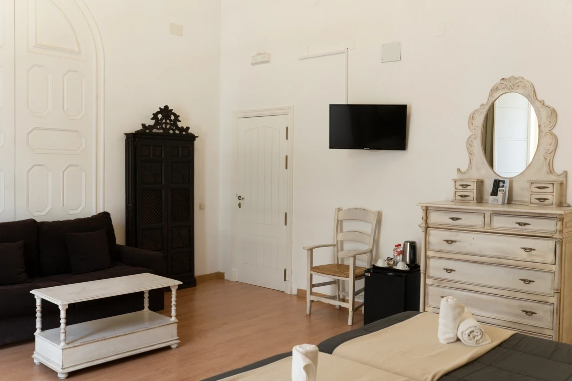 Habitación luminosa con Casual Alquimia Cádiz, sofá, armario y tocador.