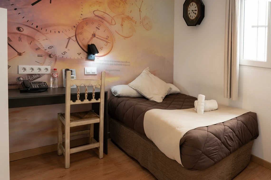 Habitación con cama cómoda, escritorio y detalle de Casual Alquimia Cádiz.