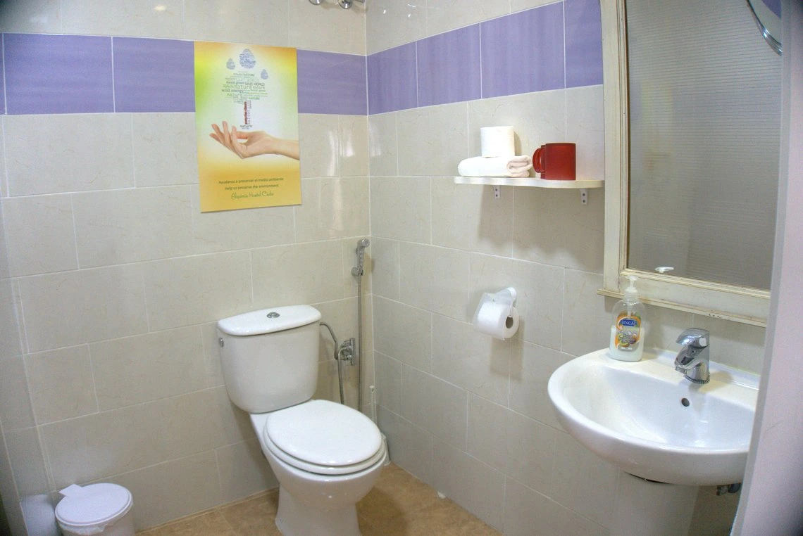 Baño limpio con inodoro y lavabo, perfecto para tu Casual Alquimia Cádiz.